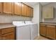 Functional laundry room with matching washer and dryer, wooden cabinets and counters, providing ample storage at 3925 N 160Th Ave, Goodyear, AZ 85395