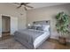 Spacious main bedroom with a ceiling fan, a grey bed, a plant, and soft lighting for a comfortable retreat at 3925 N 160Th Ave, Goodyear, AZ 85395