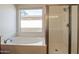 Bright bathroom featuring a soaking tub and glass-enclosed shower with modern fixtures at 3971 E Leo Pl, Chandler, AZ 85249