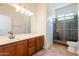 Bathroom showcasing vanity with wood cabinets and a shower with marble tile at 3971 E Leo Pl, Chandler, AZ 85249