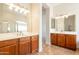 Dual sinks with wooden cabinetry, large mirrors, and modern fixtures in a well-lit bathroom at 3971 E Leo Pl, Chandler, AZ 85249