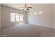 Spacious bedroom with neutral carpet, ceiling fan, and a large window providing natural light at 3971 E Leo Pl, Chandler, AZ 85249