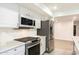 Kitchen featuring stainless steel appliances, white countertops and cabinetry, microwave and gray backsplash at 4628 W Solano S Dr, Glendale, AZ 85301