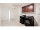 Well-equipped laundry room with black washer and dryer, ample storage, and easy access to other areas at 4628 W Solano S Dr, Glendale, AZ 85301