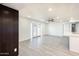 Open-concept living room with new gray flooring, neutral walls and white trim, and large french doors at 4628 W Solano S Dr, Glendale, AZ 85301