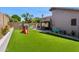 Spacious backyard featuring artificial grass, a play structure, and outdoor furniture at 4704 E Melinda Ln, Phoenix, AZ 85050