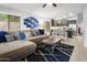 Comfortable living room featuring a plush sofa, modern decor, and open access to the kitchen at 4704 E Melinda Ln, Phoenix, AZ 85050