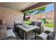 Covered patio with comfortable seating, fire pit, and views of the backyard play area at 4704 E Melinda Ln, Phoenix, AZ 85050