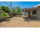 Spacious backyard featuring a covered patio and mature trees providing ample shade at 5029 W Osborn Rd, Phoenix, AZ 85031