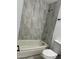 Tiled bathroom featuring a bathtub and updated fixtures at 5029 W Osborn Rd, Phoenix, AZ 85031