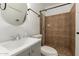 Nicely tiled bathroom with a round mirror, stylish sink, and shower with updated fixtures at 5029 W Osborn Rd, Phoenix, AZ 85031