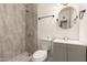 Nicely tiled bathroom with a round mirror, stylish sink, and shower with updated fixtures at 5029 W Osborn Rd, Phoenix, AZ 85031