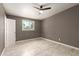 This bedroom has tiled floors, a ceiling fan, natural light from a window, and a neutral color scheme at 5029 W Osborn Rd, Phoenix, AZ 85031