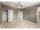 Bedroom features tiled floors, a ceiling fan, and closet space with an adjoining bathroom at 5029 W Osborn Rd, Phoenix, AZ 85031