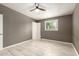 Bright bedroom features tile flooring, ceiling fan, a window and an open door that welcomes ample natural light at 5029 W Osborn Rd, Phoenix, AZ 85031