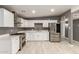 Modern kitchen with stainless steel appliances, white cabinets, quartz countertops, and tiled floors at 5029 W Osborn Rd, Phoenix, AZ 85031