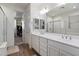 Bright bathroom with double sink vanity, glass shower, walk-in closet, and wood-look tile floors at 5661 S Dante --, Mesa, AZ 85212