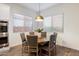 A bright dining area featuring a round table, six chairs, natural light, and modern pendant lighting at 5661 S Dante --, Mesa, AZ 85212