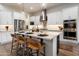 Stylish kitchen with stainless appliances, a center island with barstool seating and elegant pendant lighting at 5661 S Dante --, Mesa, AZ 85212
