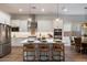 Elegant kitchen with stainless appliances, a center island with barstool seating, and stylish pendant lighting at 5661 S Dante --, Mesa, AZ 85212
