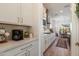 Bright kitchen featuring white cabinets, modern appliances, and a view into the adjacent dining area at 5661 S Dante --, Mesa, AZ 85212