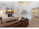 The living room with a cozy fireplace, large leather sofa, and a rustic coffee table creating a comfortable space at 5661 S Dante --, Mesa, AZ 85212