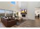 A spacious living room boasts high ceilings, large windows, fireplace, and a comfortable leather sofa at 5661 S Dante --, Mesa, AZ 85212