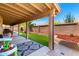 Relaxing covered patio featuring artificial turf, brick accents, and a charming outdoor rug for added comfort and style at 5912 W Gail Dr, Chandler, AZ 85226