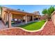 Spacious backyard featuring lush artificial grass, covered patio, and brick-lined flower beds for a serene outdoor experience at 5912 W Gail Dr, Chandler, AZ 85226