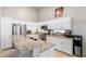 Bright kitchen boasts white cabinets, stainless steel appliances, granite countertops, and an island with a sink at 5912 W Gail Dr, Chandler, AZ 85226