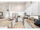 Bright kitchen boasts white cabinets, stainless steel appliances, granite countertops, and an island with a sink at 5912 W Gail Dr, Chandler, AZ 85226