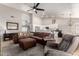 Spacious living room with a brown sectional, ceiling fan, and an open floor plan adjacent to the kitchen at 5912 W Gail Dr, Chandler, AZ 85226