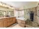 Bright main bathroom featuring a double sink vanity, soaking tub, and glass enclosed shower with tile surround at 5912 W Gail Dr, Chandler, AZ 85226