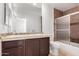 Bathroom with dual sink vanity, a shower-tub combo and tile accents at 6320 S 26Th Dr, Phoenix, AZ 85041