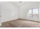 Bedroom with neutral carpet, trim and a large window that lets in natural light at 6320 S 26Th Dr, Phoenix, AZ 85041