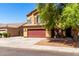 Two-story home with a brick red garage door, desert landscaping, and tan siding at 6320 S 26Th Dr, Phoenix, AZ 85041