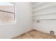Bright laundry room features built-in shelves and a window for natural light at 6320 S 26Th Dr, Phoenix, AZ 85041