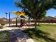 Community playground with shaded seating, a colorful play structure, and a grassy area at 6320 S 26Th Dr, Phoenix, AZ 85041
