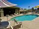 Community pool with lounge chairs, shaded seating, and clear blue water at 6320 S 26Th Dr, Phoenix, AZ 85041