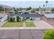 Front exterior of a well-maintained home with desert landscaping, a lawn, and a basketball hoop at 6608 E Lewis Ave, Scottsdale, AZ 85257