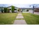 Charming single-story home featuring desert landscaping, a basketball hoop, and a well-manicured lawn at 6608 E Lewis Ave, Scottsdale, AZ 85257