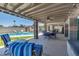 Outdoor patio with poolside lounge area and dining set-up featuring a ceiling fan and string lights at 6838 E Belleview St, Scottsdale, AZ 85257