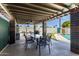 Covered outdoor patio featuring a dining table, bar-b-que, and a view of the pool at 6838 E Belleview St, Scottsdale, AZ 85257