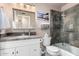 Bathroom featuring granite counters, shower over tub, decorative light fixture and framed mirror at 6838 E Belleview St, Scottsdale, AZ 85257