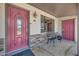 Charming front porch with decorative door, stone accents, seating, and inviting curb appeal at 6838 E Belleview St, Scottsdale, AZ 85257