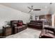 Open-concept living room featuring hardwood floors and comfortable, dark brown leather furniture at 6838 E Belleview St, Scottsdale, AZ 85257