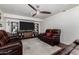 Comfortable living room with cozy leather seating, custom shelving, and a modern ceiling fan at 6838 E Belleview St, Scottsdale, AZ 85257