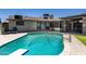 Sparkling pool with diving board, patio, green lawn, and covered dining space at 6838 E Belleview St, Scottsdale, AZ 85257