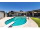 Outdoor pool with attached covered patio, diving board, and green lawn at 6838 E Belleview St, Scottsdale, AZ 85257