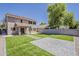 Spacious backyard features manicured artificial turf, stone patio, block fence, and ample room for outdoor enjoyment at 763 E Maddison St, San Tan Valley, AZ 85140